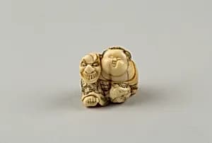 Netsuke of Okame Holding a Mask by Unknown Artist