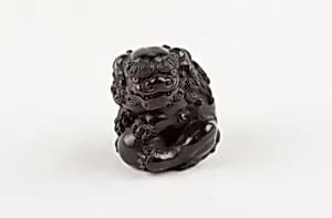 Netsuke of Seated Shishi Clutching a Ball by Ryōzan