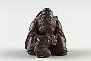 Netsuke of Man with a Demon on a Chain by Unknown Artist