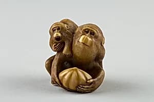 Netsuke of a Female Monkey Holding a Nut while her Baby Crawls on her Back by Masatami