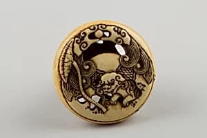 Netsuke Carved with Shishi; reverse with Lotus Leaf by Rensai