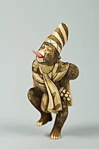 Netsuke of Monkey Wearing a Tall Cap and Carrying a Fan by Unknown Artist