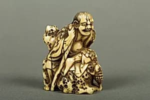 Netsuke of Old Man Sitting on a Rock by Unknown Artist
