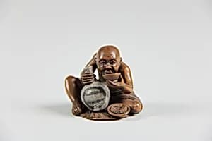 Netsuke of a Man Holding a Small Bottle in One Hand and Drinking from a Cup by Unknown Artist