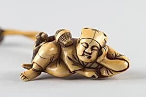 Netsuke of a Man Sleeping while Monkey Steals Contents of Basket by Unknown Artist