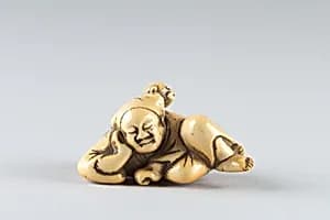 Netsuke of a Man Sleeping while Monkey Steals Contents of Basket by Unknown Artist