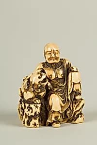 Netsuke of Man and a Qilin Sitting on a Rock by Unknown Artist