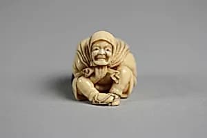 Netsuke of Old Man Carrying a Bag of Ōni (Demons) by Unknown Artist