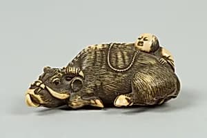 Netsuke of Boy Climbing over the Back of a Cow by Unknown Artist