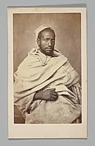 [Studio Portrait: Seated Man, Algeria] by Unknown