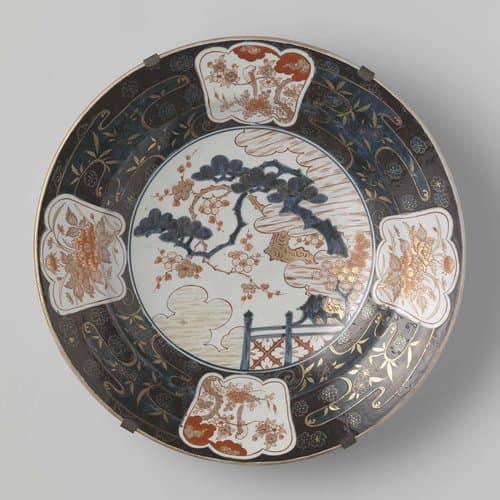 Dish with a prunus tree behind a fence and flower sprays by anonymous