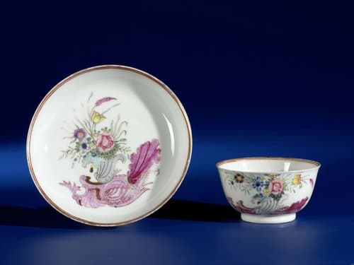 Bell-shaped cup and saucer with a snailornament and flowering plants by anonymous
