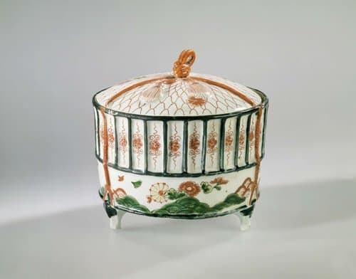 Cilidrical covered box in the shape of a cricket's cage by anonymous