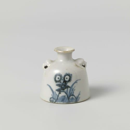 Jar with flower sprays behind rocks by anonymous