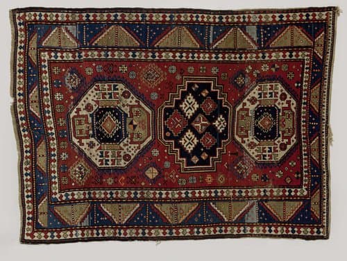 Tapijt met op rode grond drie medaillons gevuld met geometrische figuren. Drie randen; middelste door diagonalen in groene en blauwe driehoeken verdeeld. by anonymous