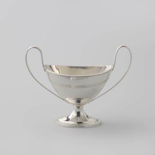 Suikervaas van zilver, ovaal op gewelfde voet en met twee hoge oren. Versierd met filetranden.