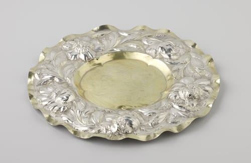 Schaal van zilver, rond, gedeeltelijk verguld. Op de brede rand met gegolfde omtrek ranken en bloemen in hoog reliëf. by anonymous